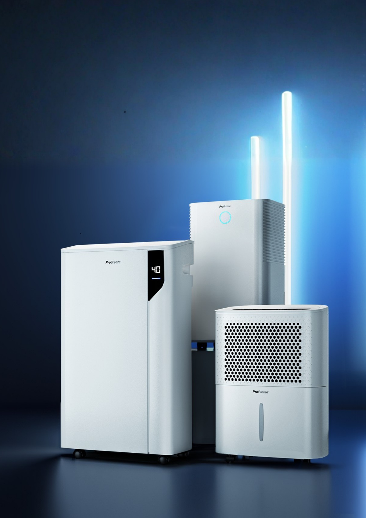 Three white Pro Breeze air quality appliances, including a large air purifier, a humidifier, and a dehumidifier, arranged together on a dark blue studio background with blue light accents.